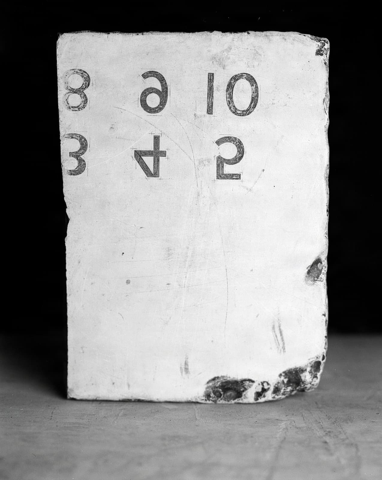 Close-up of Lithography Stone with Stenciled Numbers and Letters